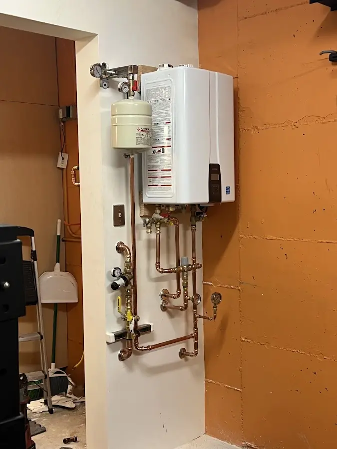 Plumbing technician inspecting water heater connections in Northampton